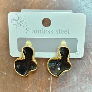 Detailopname van geometrische wolkoorbellen met zwart emaille en een gouden afwerking.
