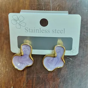 Detail van vintage geometrische wolk oorbellen met lavendel emaille en gouden randen.