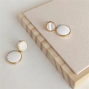 Detailed view of elegant white geometric double circle stud earrings with gold trim