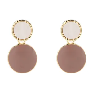Close-up of elegant double circle enamel stud earrings with gold trim in dusty pink and white