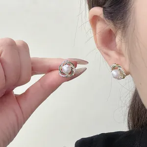Eleganti orecchini a perno in stile francese con strass e finitura dorata raffinata.