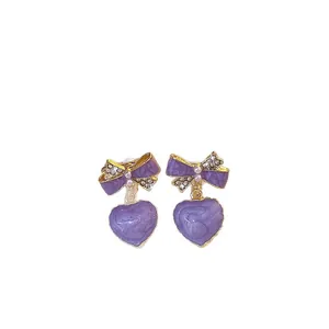 Elegant lavender purple heart-shaped earrings featuring a pearl-embellished bow design