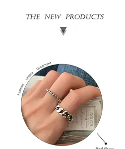 Detailed view of vintage silver braided twist and chunky chain link rings on model hand
