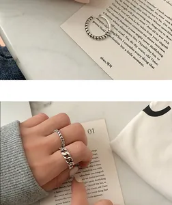Close-up detail of retro distressed silver twist and chain link rings on hand