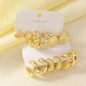 Detailed view of gold earring set with chunky C-shaped hoops and textured shell studs