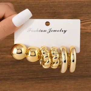Detailed macro view of a 3-pair gold earring set featuring hoop and twisted designs