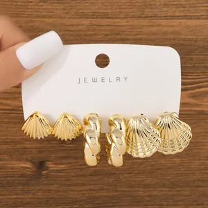 Detailed view of 3-pair gold fashion earring set featuring shell and twisted C-shapes