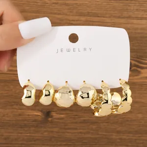 Detail view of fashion gold earring set featuring C-shape and water-drop designs