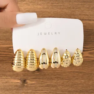 Detail of gold teardrop earring set with ribbed, smooth, and hammered textures.