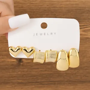 Detail view of 3-pair gold earring set featuring heart, C-shape, and drop designs