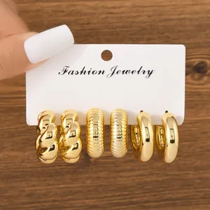 Detail view of three pairs of textured and smooth gold-plated chunky hoop earrings set.
