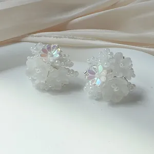Detail view of white hydrangea flower stud earrings with pearlescent bead and petal texture