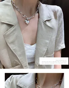 Close-up detail of a chunky S925 sterling silver chain necklace with heart pendant.