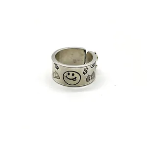 Close-up of retro 925 sterling silver ring with engraved smiley face and dollar sign patterns