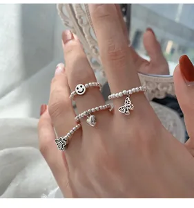 Detailansicht von 925 Sterling Silber Perlenringen mit Schmetterlings- und Herzanhängern.