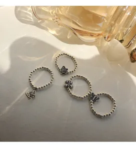 Nahaufnahme von Vintage 925er Sterling Silber Perlenringen mit Schmetterlingsanhängern