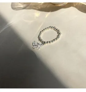 Detailansicht eines Kugelrings aus 925er Sterlingsilber mit Schmetterlingsanhänger.