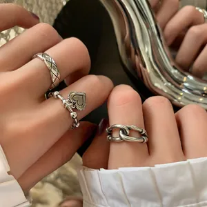 Detailed macro view of S925 sterling silver rings with heart and chain design elements