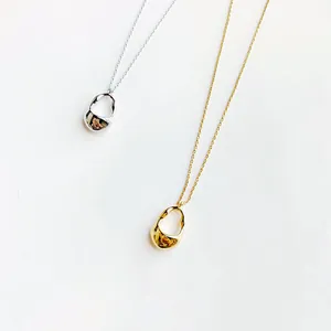 Vista dettagliata di collane con pendente irregolare minimalista in argento e oro