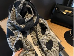 Detailed view of the heart pattern and plaid texture on this warm imitation cashmere scarf
