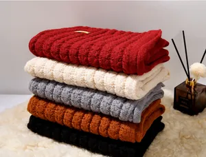 Pila di sciarpe a maglia colorate con trama a coste in rosso, crema, grigio, marrone e nero