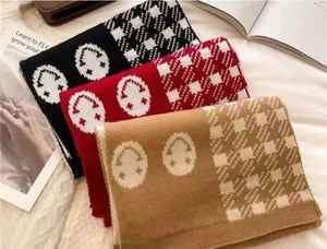 Detail view of thickened knit plaid scarves with smiley face patterns in three colors.