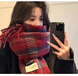 Détail d'une écharpe à carreaux rouge et bleu en imitation cachemire avec bords à franges