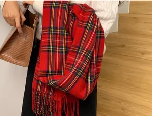 Close-up of a soft red plaid scarf with classic fringe detail for winter warmth