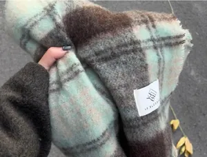 Close-up of a thick mohair plaid scarf with mint green and brown check pattern