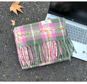 Detailed view of pink and green plaid imitation cashmere scarf with soft tassels and tag.