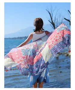 Detailed view of a vibrant ethnic style shawl held against a beautiful lake background
