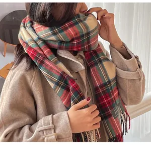 Detailed view of thick checkered cashmere-like scarf with fringe on model's beige coat
