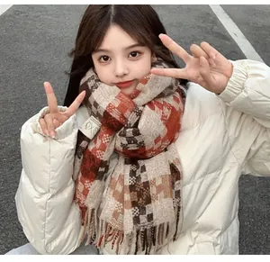 Stylish orange and brown plaid tassel scarf worn by a female model in a white winter jacket