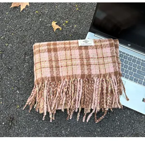 Detailed view of pink and brown plaid scarf texture with Ye Blossom brand label