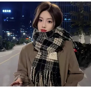 Thick winter plaid scarf with fringe tassels worn by a model in city street style.