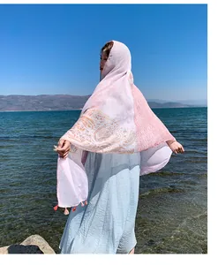 Ethnic style paisley print shawl wrap worn by a model at a sunny seaside beach resort