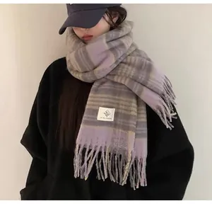 A detailed view of a cozy mohair plaid scarf featuring purple and grey tassels