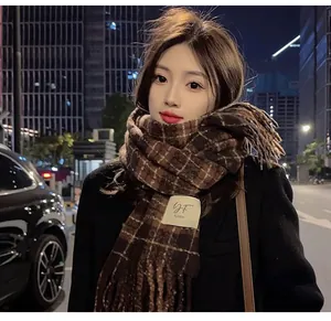 Detailed view of a brown plaid imitation cashmere scarf worn by an Asian female model at night