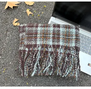 Detailed view of a soft checkered imitation cashmere scarf with stylish fringe edges