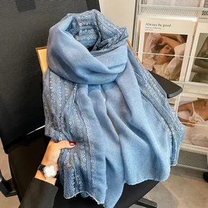 Detailed view showing the intricate lace stitching on a soft light blue cotton linen scarf