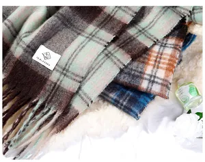 Close-up of thick plaid mohair scarves with tassels showing texture and various colors