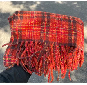 Detailed texture of red plaid imitation cashmere scarf with tassels and fringe