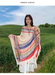 Detail of ethnic style shawl with colorful stripes and red tassels for vacation.
