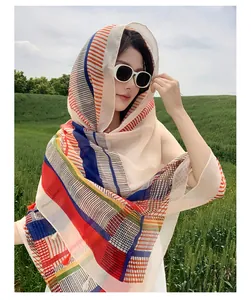 Close-up of vibrant ethnic style shawl with colorful stripes on a model in nature setting