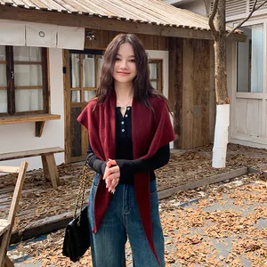 Elegant burgundy knitted triangle shawl wrap for women shown in a cozy autumn outdoor setting.