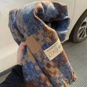 Soft winter woven plaid scarf in blue and brown cashmere-like shawl held by hand