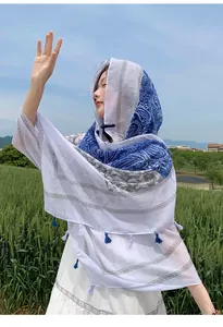Ethnic style blue and white paisley shawl wrap with toggle button and tassels on model