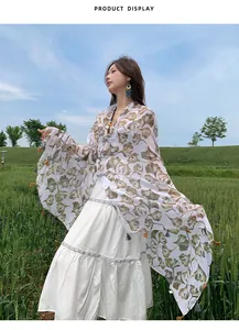 Ethnic ginkgo leaf pattern shawl with vintage frog fasteners on a model in a field