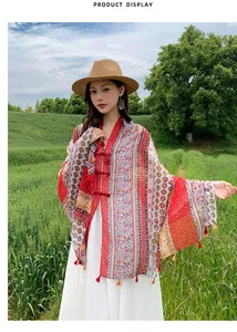 Vintage ethnic style patterned shawl with tassels and frog buttons in nature scene