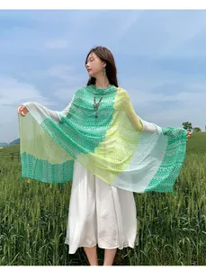 Elegant ethnic green shawl with retro frog button detail in a scenic wheat field